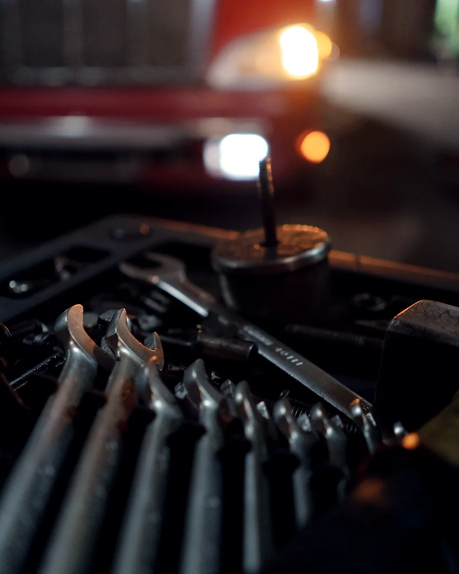 A stack of open-ended wrenches on a bench under warm light.
